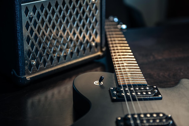 Closeup black electric guitar on a dark background