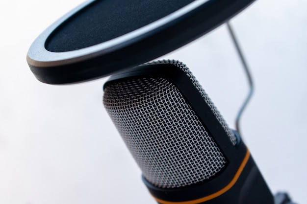 Closeup of a black and grey microphone captured on a white background