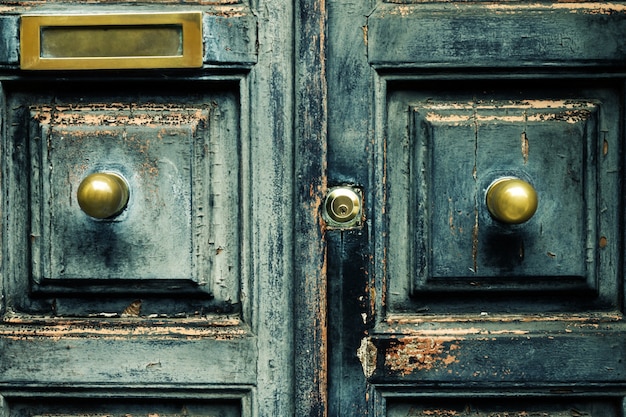 Free photo closeup of blue turquoise old textured antique door with gold bronze door handle and keyhole.