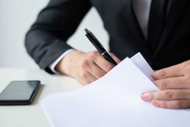 Free photo closeup of business man signing document at office desk