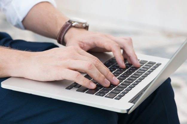 Free photo closeup of business man working on laptop outdoors