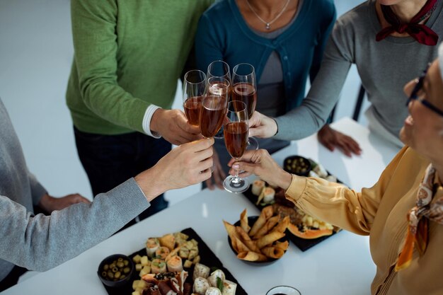 Closeup of business people toasting with Champagne on office party