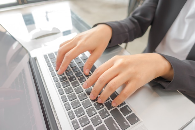 Free photo closeup of business woman hand typing on laptop keyboard .