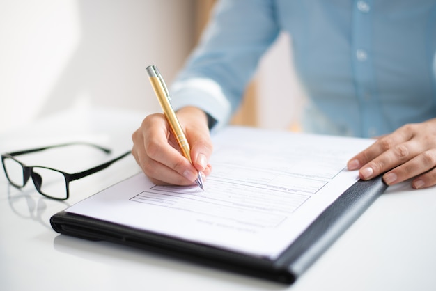 Free photo closeup of business woman making notes in document