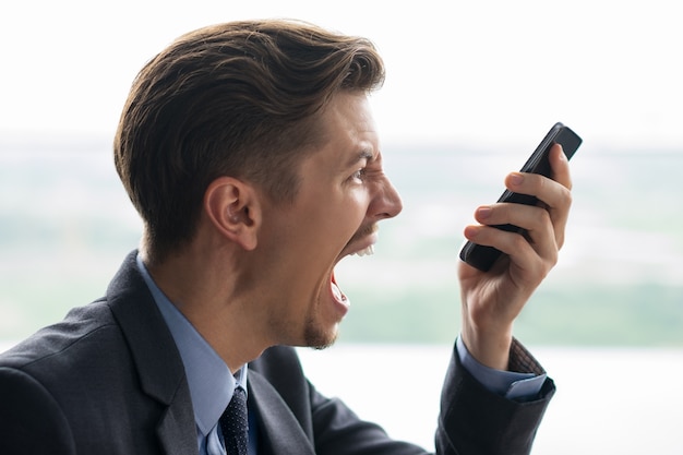 Closeup of Businessman Shouting at Smartphone