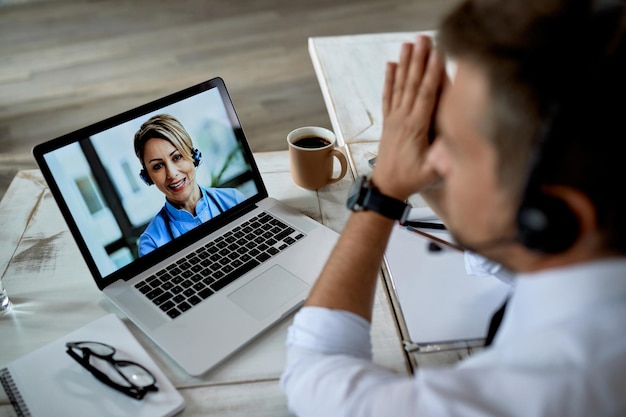 Free Photo closeup of businessman using computer while having video call with his doctor from the office