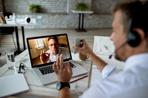 Free Photo closeup of businessman using laptop while making video call with a colleague from the office