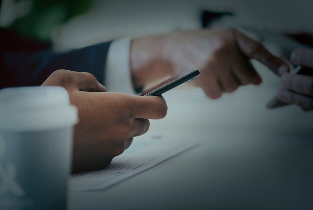 Closeup of businessmen using mobile phone