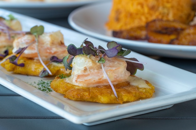 Closeup of canape with chicken and fish with herbs on it