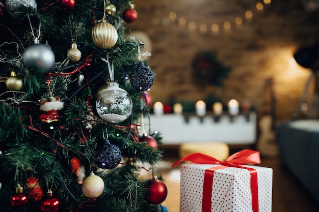 Closeup of Christmas tree and wrapped gift at home