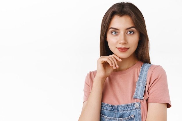 Closeup confident sassy female professional look successful and determined touching chin smiling pleased and pensive have interesting creative idea in mind stand white background