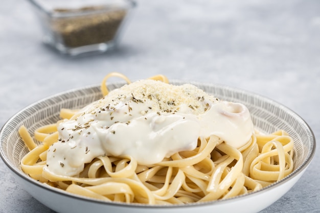 Free photo closeup of cooked fettuccine with cream and spices in a bowl under the lights