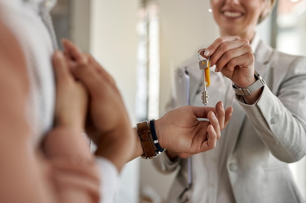 Free photo closeup of a couple receiving keys of their new apartment from real estate agent