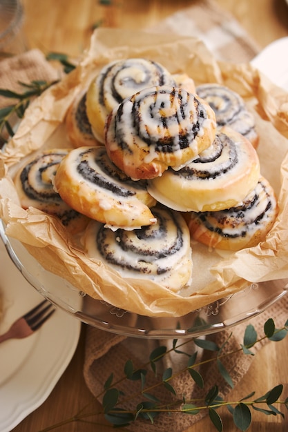 Free Photo closeup of delicious poppy snail pastries with a sugar glaze on a wooden table