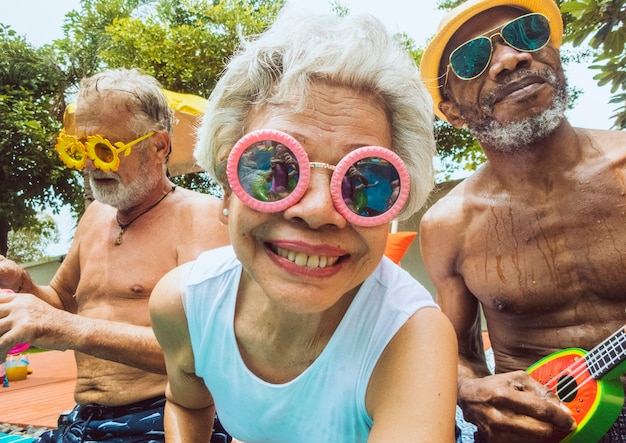 Free photo closeup of diverse senior adults sitting by the pool enjoying summer together