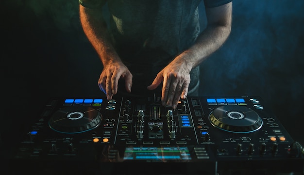 Closeup of a DJ working under the lights