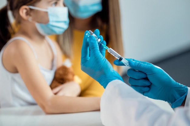 Free photo closeup of doctor preparing a syringe for child's vaccination