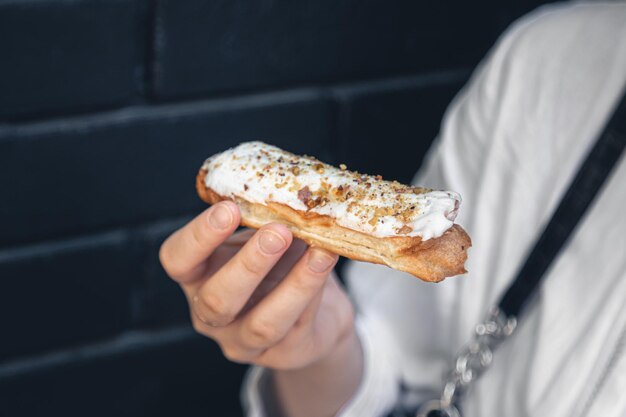 Closeup eclair cake in a female hand