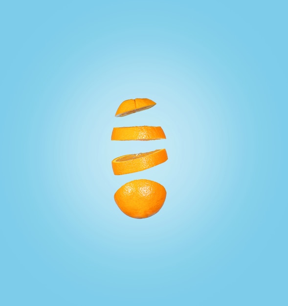 Closeup of falling orange slices isolated on a blue surface