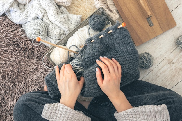 Free Photo closeup of female hands knitting grey wool sweater top view