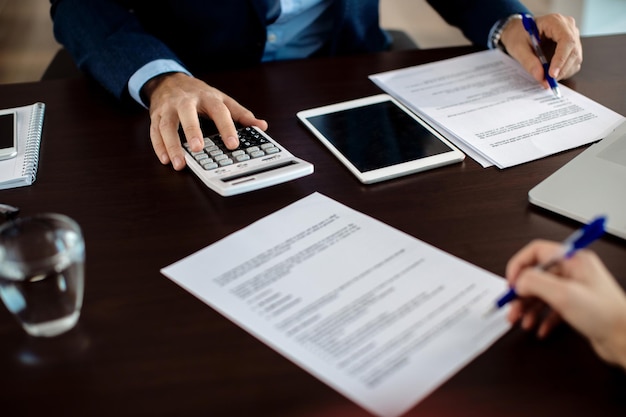 Free photo closeup of financial consultant going through paperwork on a meeting with a client