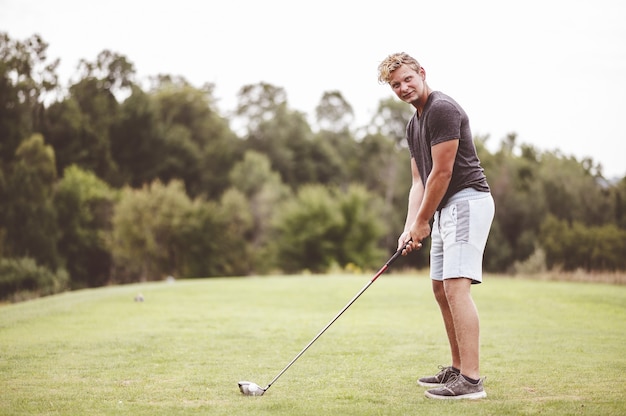 Free photo closeup focus portrait of a young man playing golf