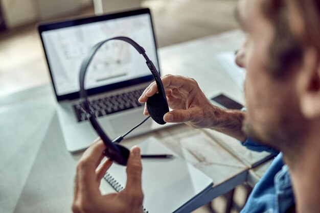 Closeup of freelance worker using headphones in the office