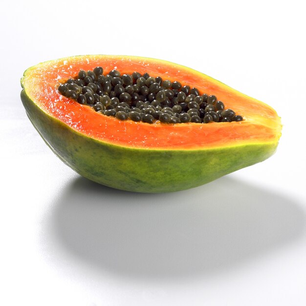 Free Photo closeup of a fresh papaya fruit sliced in half isolated on a white surface