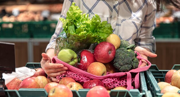 Closeup fruits and vegetables in a shopping bag in a supermarket