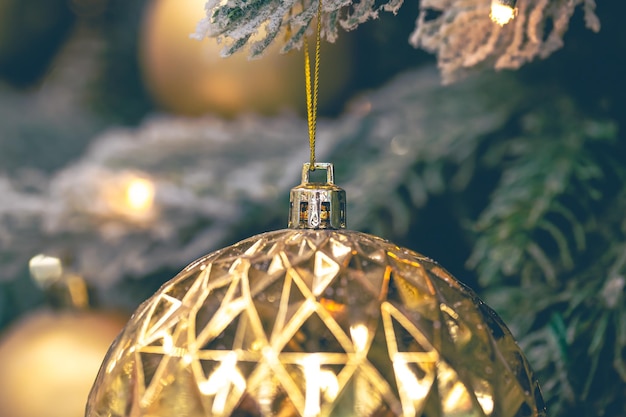 Free photo closeup golden ball on a christmas tree closeup