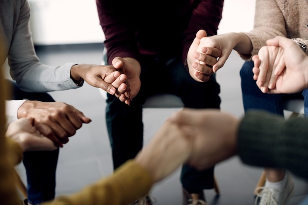 Free photo closeup of group of people holding hands during psychotherapy session