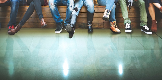 Closeup group of people legs sitting together with green floor