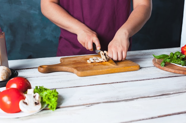 Closeup hand of chef baker making pizza at kitchen