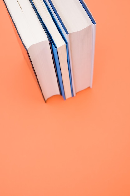 Closeup of the hardcover books on the orange surface - space for text