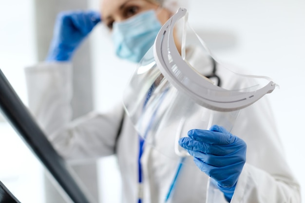 Free photo closeup of healthcare worker holding visor at medical clinic