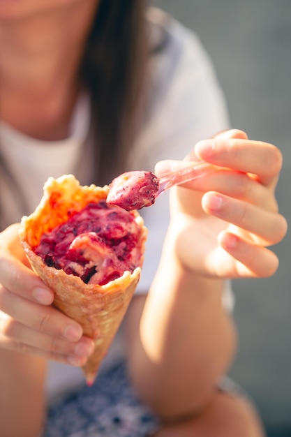 Free photo closeup ice cream in a waffle cone in female hands