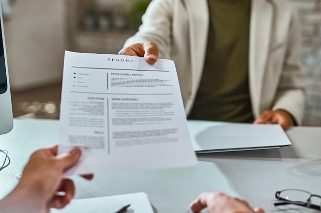 Closeup of job applicant giving his resume during job interview in the office