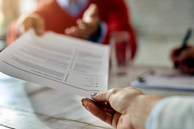 Closeup of job applicant giving his resume during job interview in the office