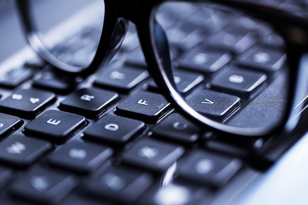 Free photo closeup of a keyboard and glasses