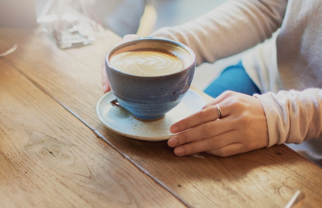 Free photo closeup of latte art coffee cup on wooden table