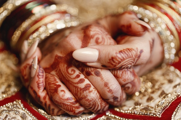 Free Photo closeup of long bride's fingers covered with mehndi and lying