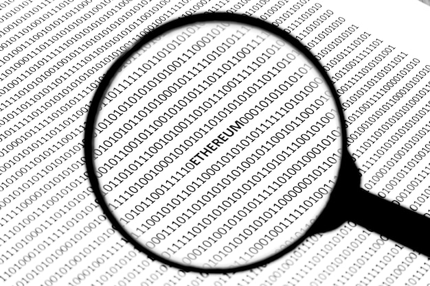 Free Photo closeup of a magnifier over the piece of paper with codes written on it