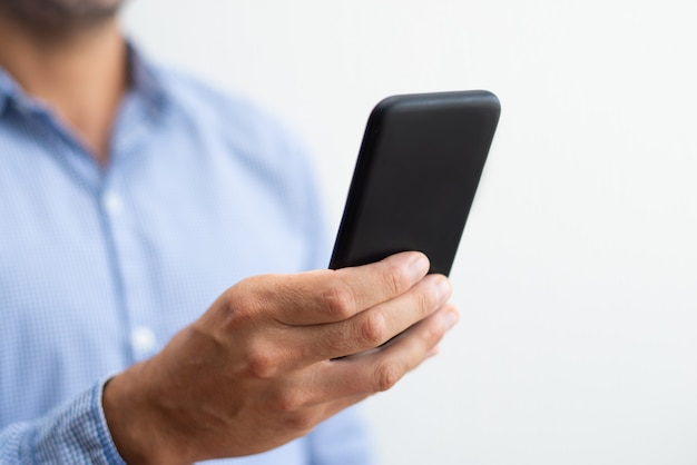 Free photo closeup of man holding and browsing on smartphone