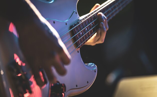 Closeup of a man playing the bass guitar