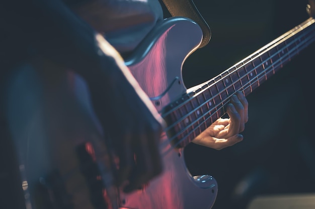 Closeup of a man playing the bass guitar