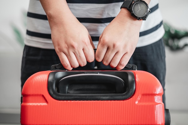 Free photo closeup of man touching luggage young man has packed his luggage and is ready to go travel holiday and vacation concept