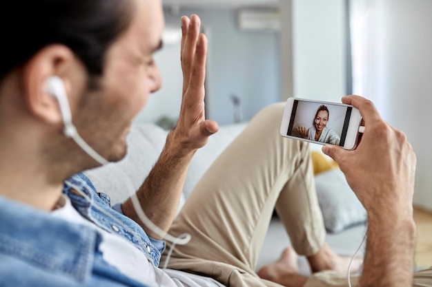 Free photo closeup of a man using mobile phone and waving while having video chat with his girlfriend