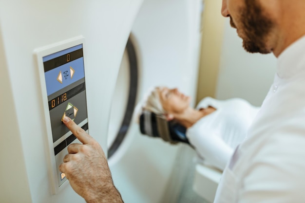 Closeup of medical technician starting MRI scan examination of a patient in the hospital