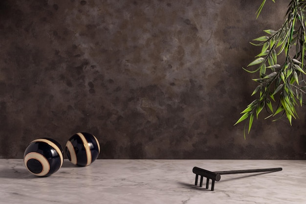 Closeup of a mini wooden rake with striped balls on the white marble surface