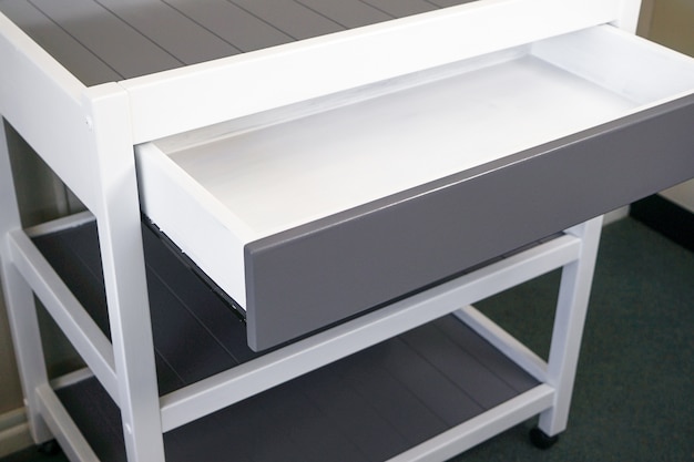 Free Photo closeup of a modern white table with a drawer under the lights